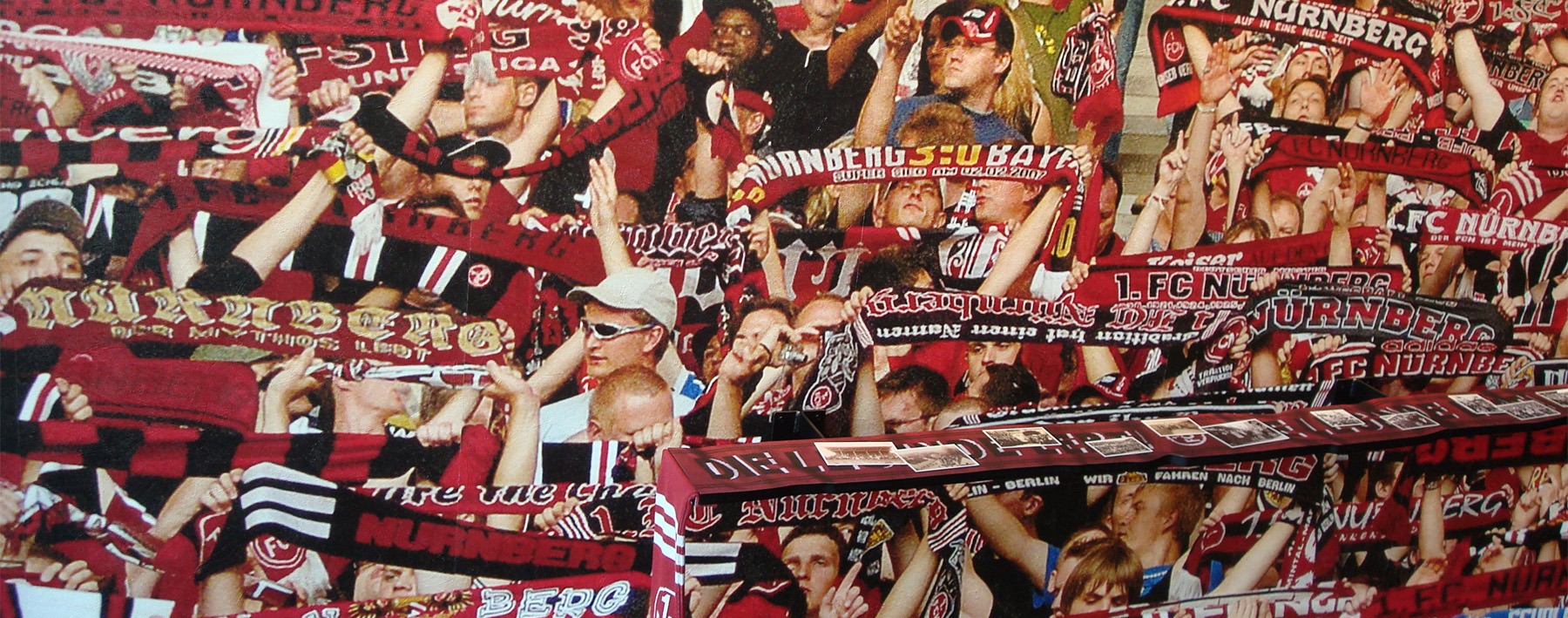Fans des 1. FC Nürnberg heben ihre Schals im Stadion