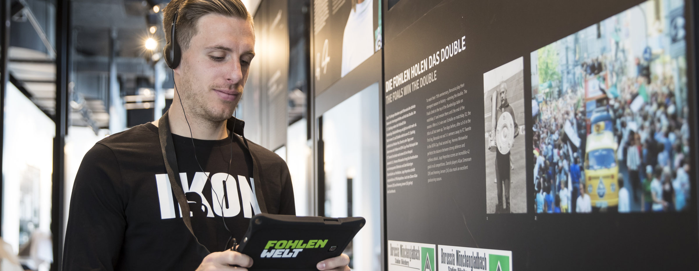 FohlenWelt Herrmann nutzt die interaktiven Möglichkeiten auf einem Tablet in der FohlenWelt, im Hintergrund eine Infowand
