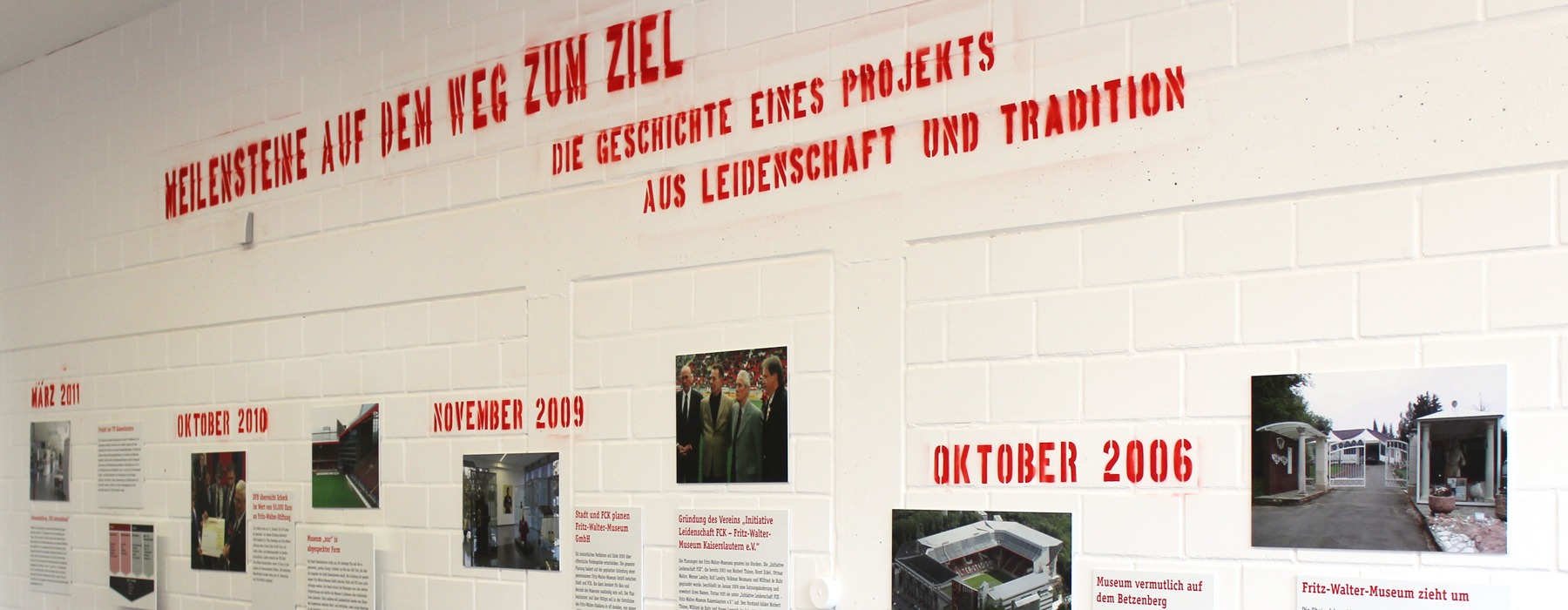 Historie aufgezeichnet in rot auf einer weißen Wand mit Ziegelsteinen.